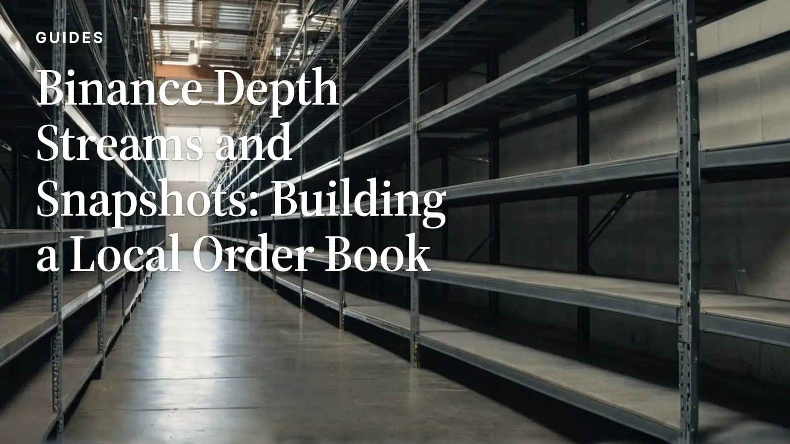 Empty steel warehouse shelving receding down a concrete aisle beneath high windows.