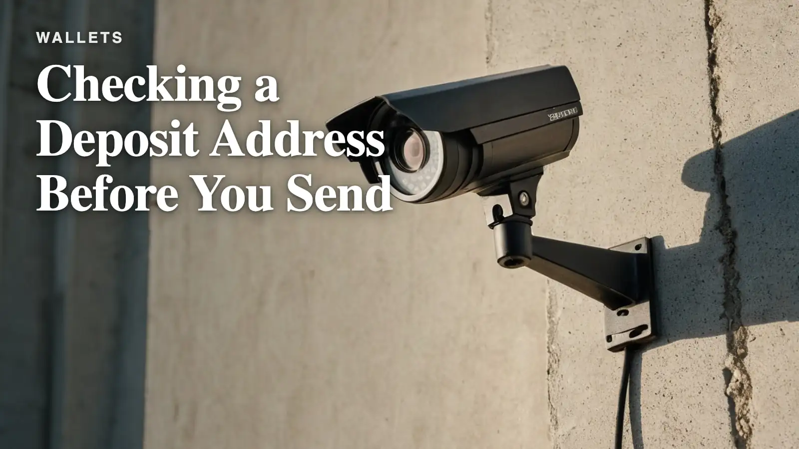 A security camera mounted on a bare concrete wall at dusk.