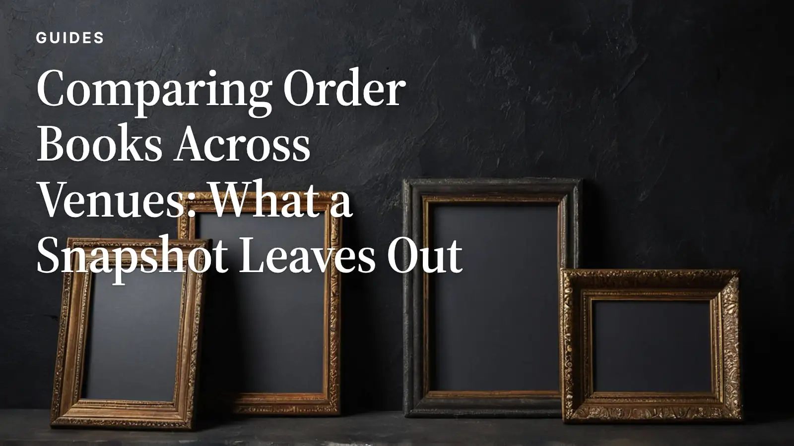 Four empty wooden picture frames of different sizes leaning against a dark wall.