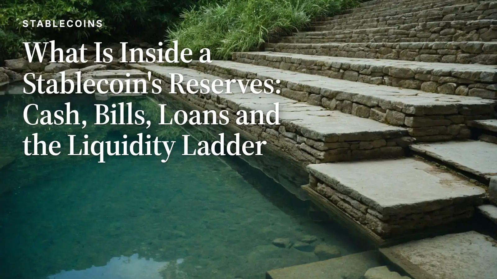A wide flight of dry stone steps descending into clear green water, the lower steps progressively submerged beneath the surface.