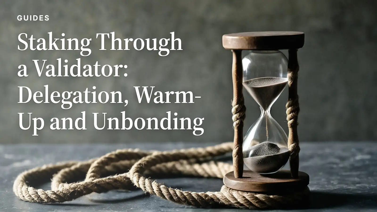 A wooden hourglass of grey sand beside a coil of hemp rope on a slate ledge.