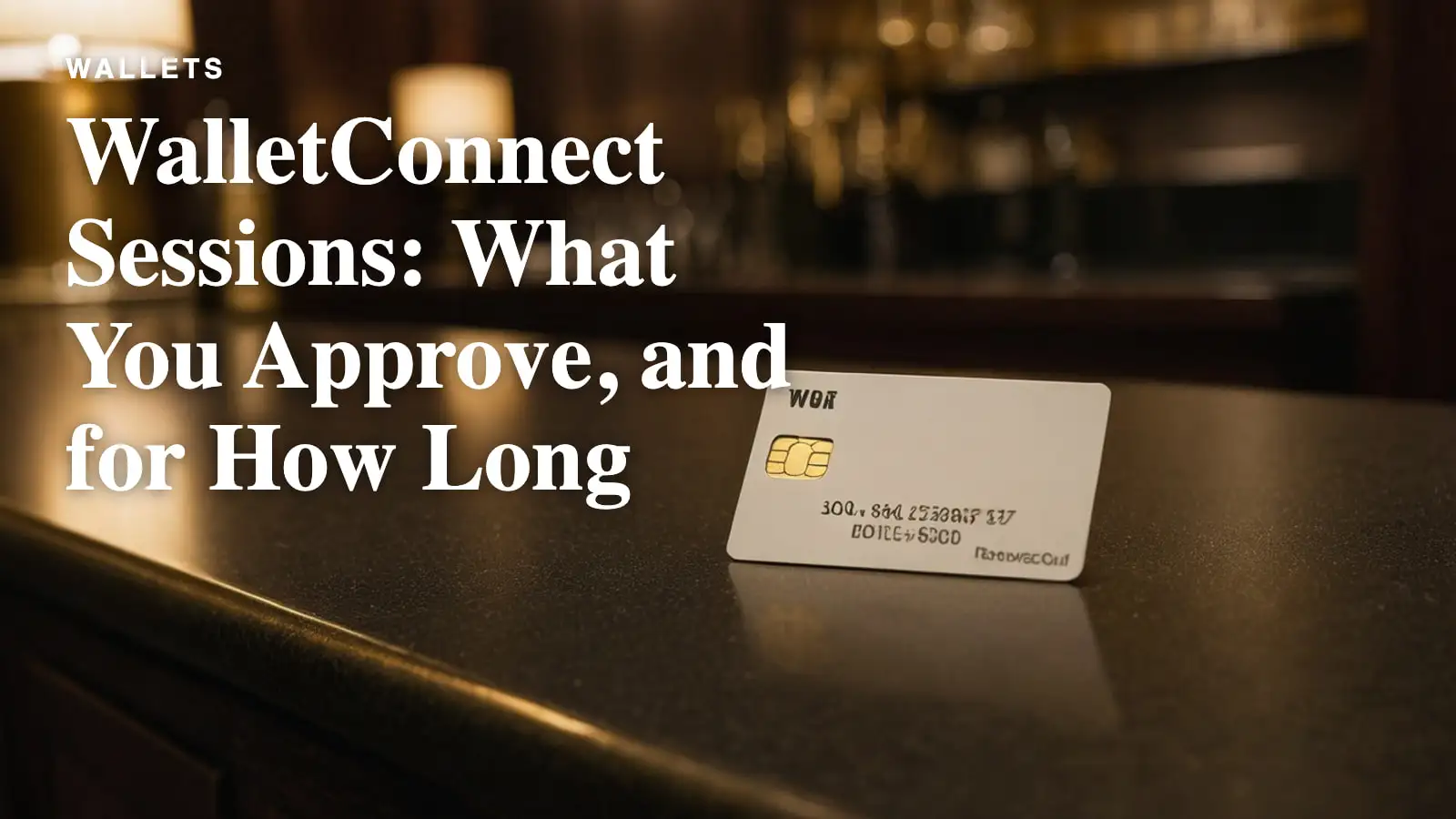 A blank white keycard with a gold chip resting on a dark polished hotel counter.